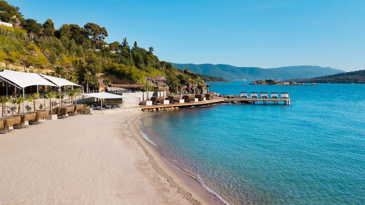 Bodrum Adabükü koylarında turkuaz deniz, doğal plajlar, çam ormanları ve sakin Ege kıyılarını yansıtan manzara.